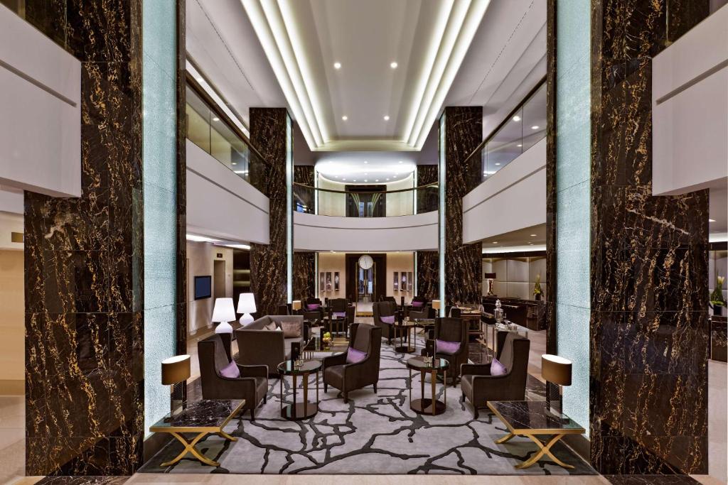 a lobby with chairs and tables in a building at Waldorf Astoria Berlin in Berlin