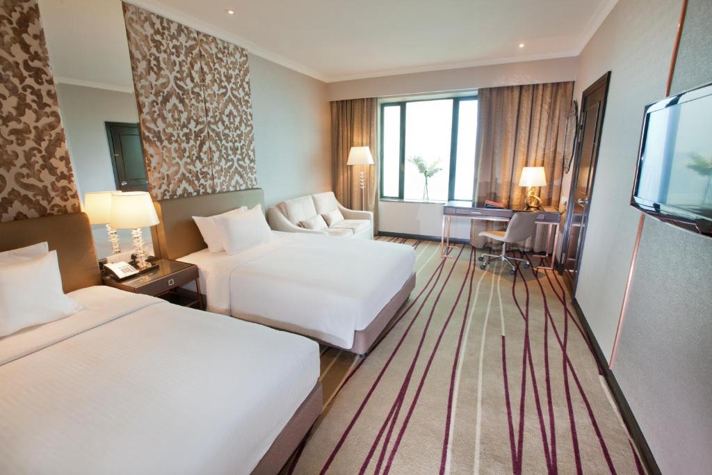 Habitación de hotel con 2 camas y TV en Dorsett Kuala Lumpur, en Kuala Lumpur