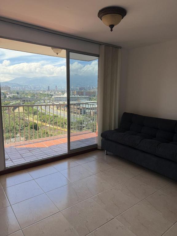 メデジンにあるApartment in Poblado 17th Floor W Poolのソファと大きな窓のあるリビングルーム