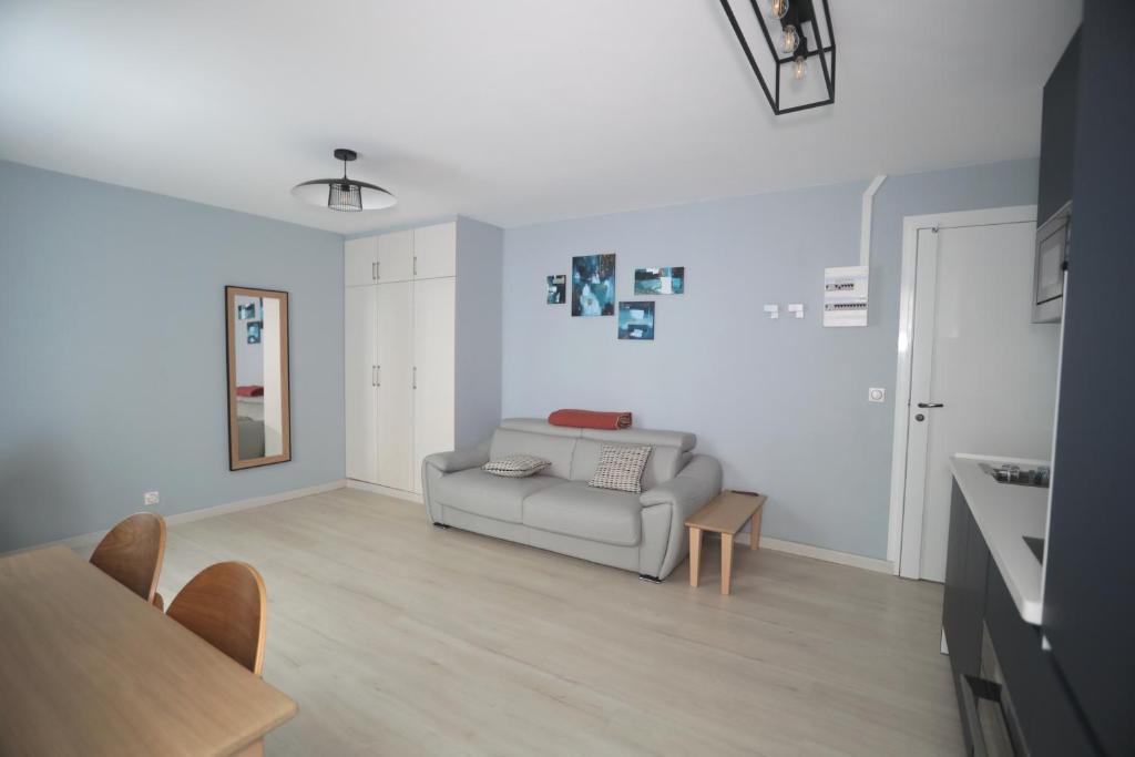 un salon avec un canapé et une table dans l'établissement Appartement élégant - Montmartre, à Paris