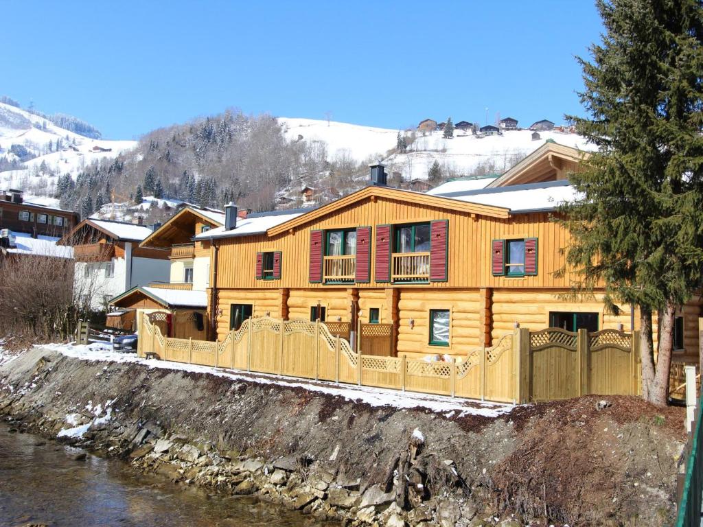drewniany dom z ogrodzeniem obok rzeki w obiekcie Kaprun Lodge - XL w Kaprunie