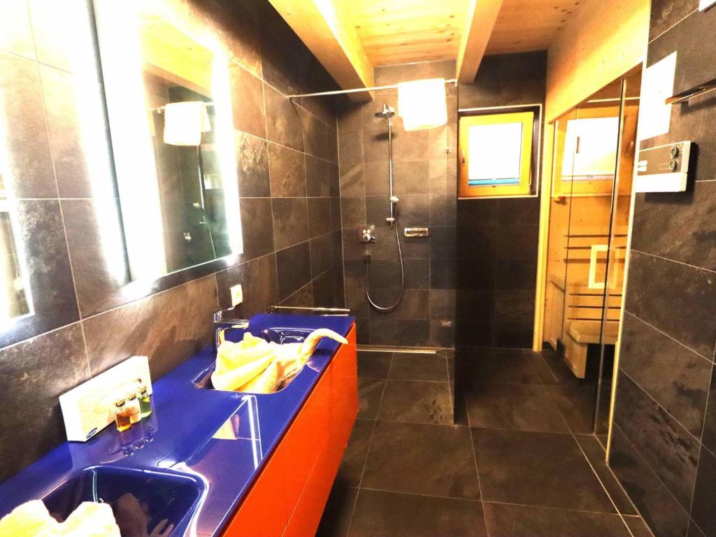 łazienka z niebieskim blatem i prysznicem w obiekcie Kaprun Lodge - XL w Kaprunie