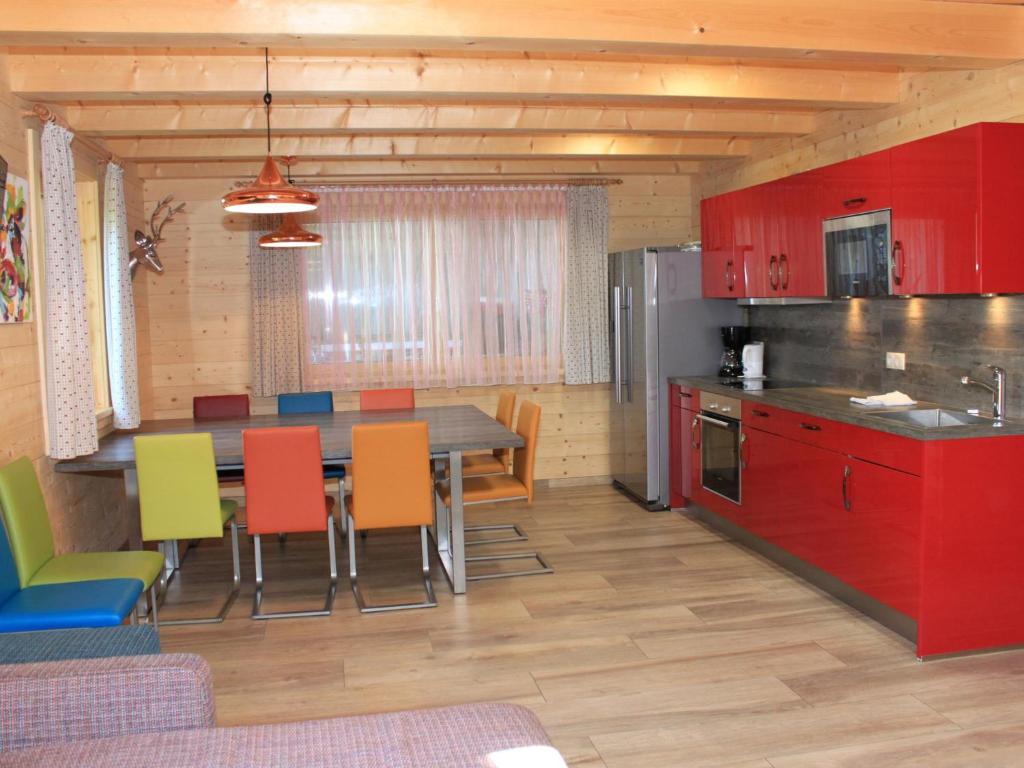 kuchnia ze stołem i kolorowymi krzesłami w obiekcie Kaprun Lodge - XL w Kaprunie
