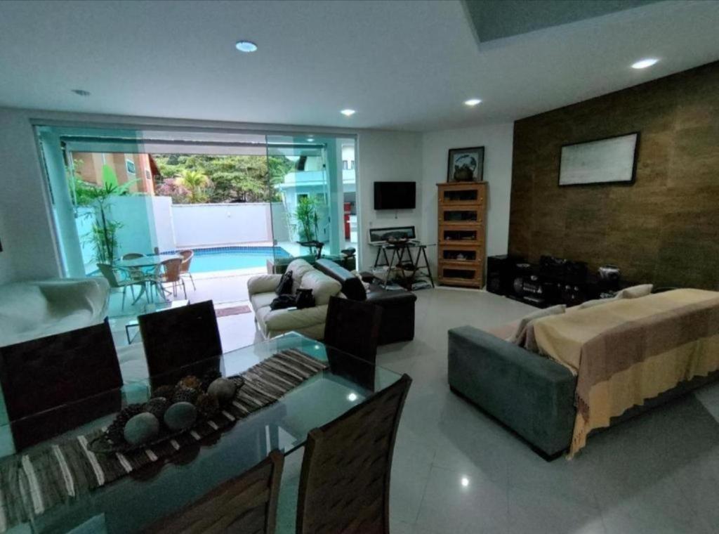 a living room with a couch and a table at Casa com piscina 2 Guarujá enseada in Guarujá