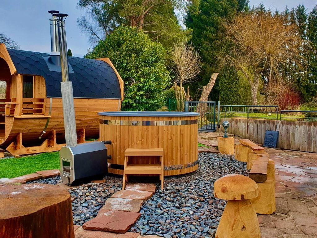 a backyard with a hot tub and a tv at Gîte de charme avec sauna, bain nordique et parc arboré au cœur des Vosges - FR-1-589-13 in Colroy-la-Grande