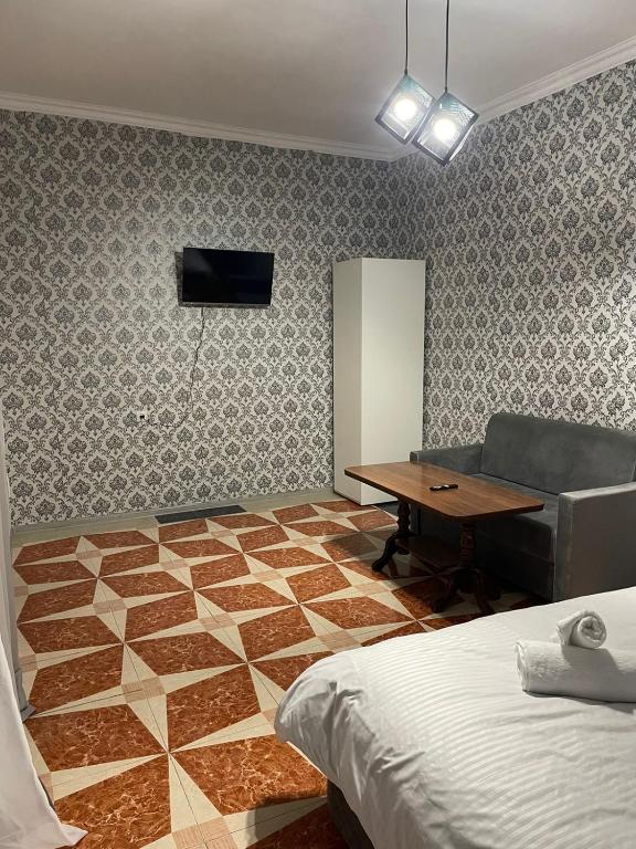 a bedroom with a desk and a bed and a table at Prime Hotel And Rental Cars 24 & 7 in Yerevan Parakar