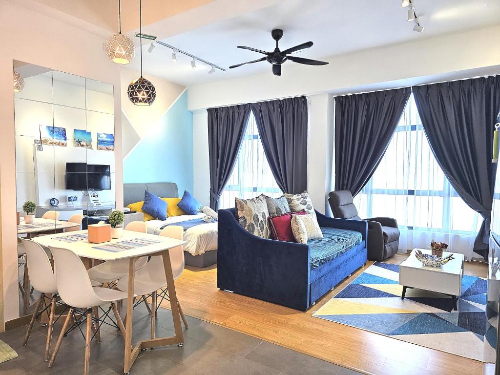 a living room with a blue couch and a table at Comfy Imperium Residence Kuantan Studio Seaview in Kuantan