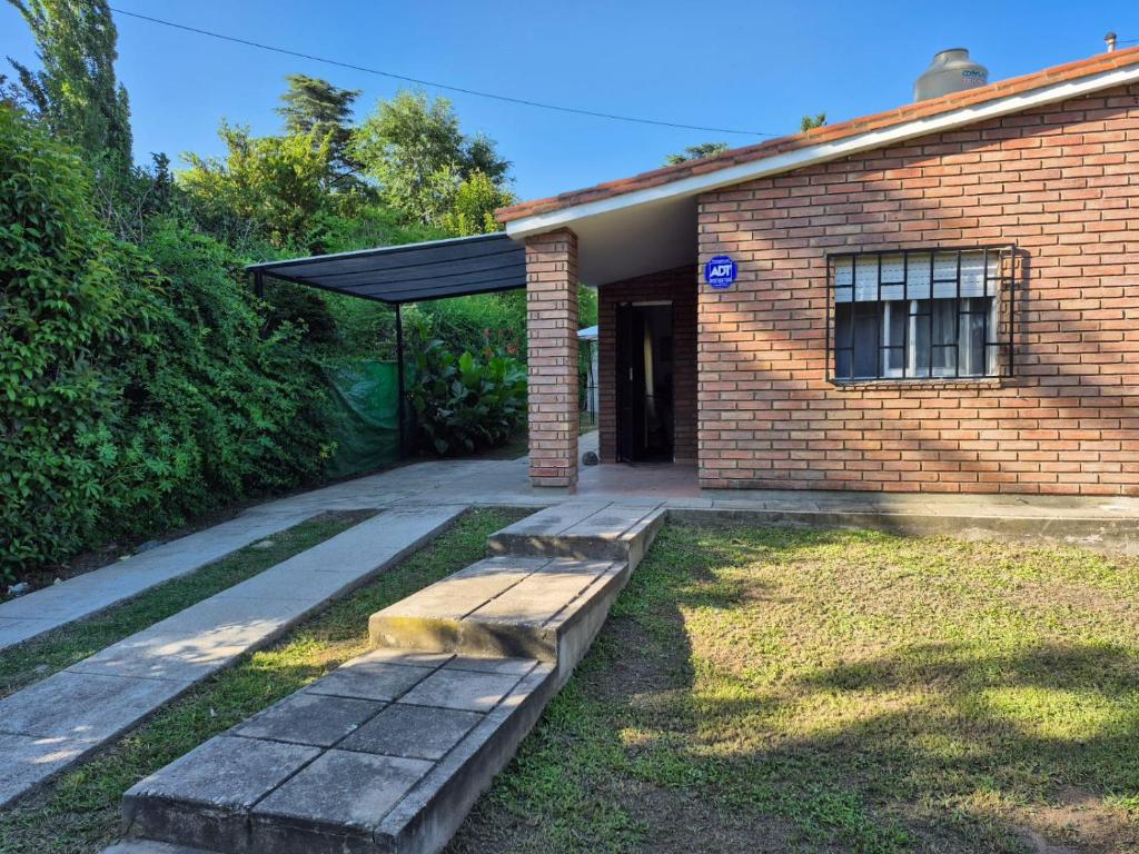 Una casa de ladrillo con un banco delante de ella. en Don EDELMI 2, en Córdoba