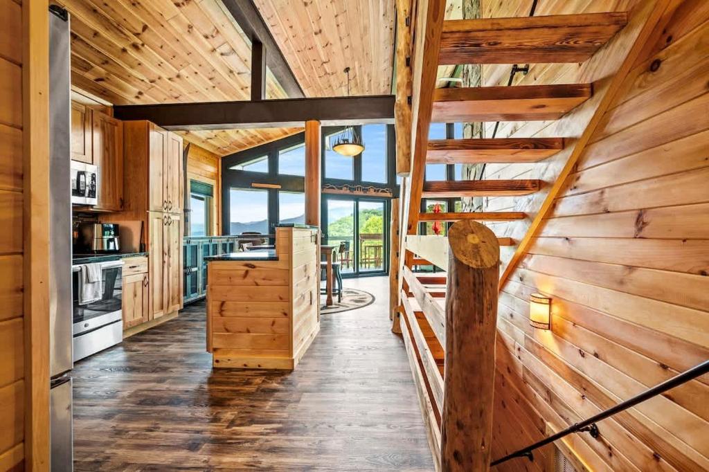 a log cabin kitchen with wooden walls and stairs at Sunrise View Chalet in Gatlinburg
