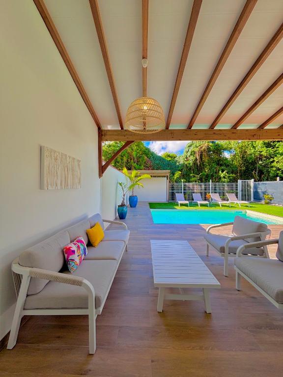 a living room with couches and a pool at La Villa Harmonie in Sainte-Luce