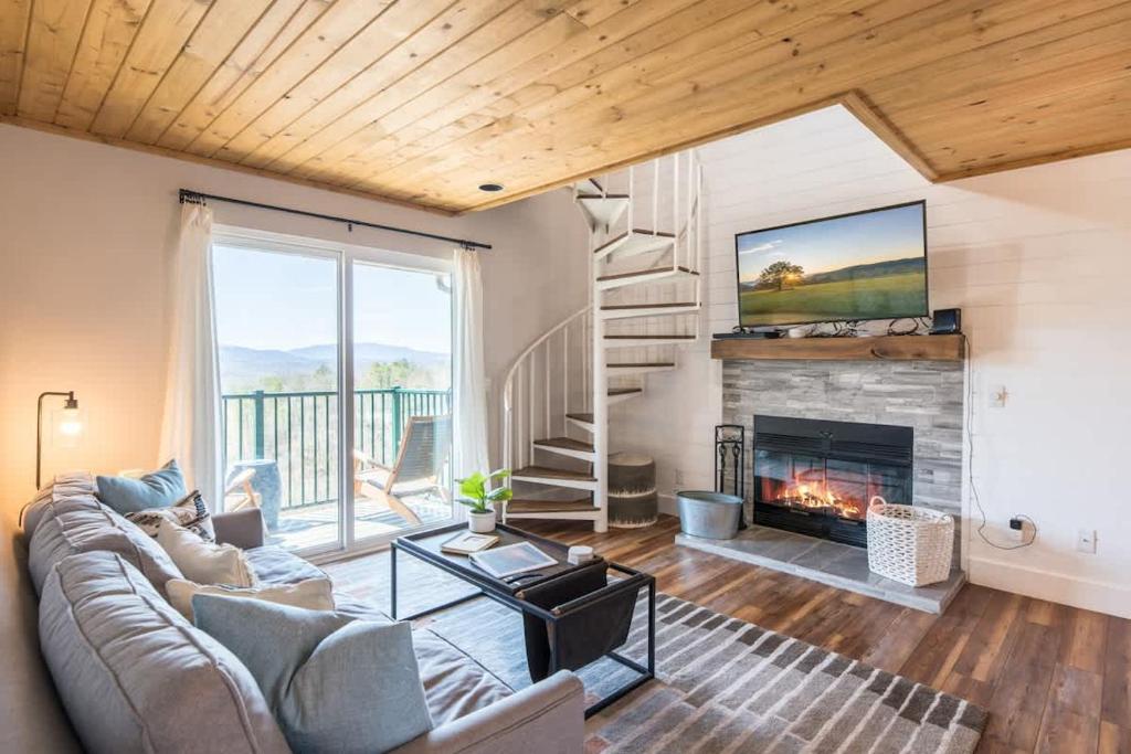 Una sala de estar con un sofá y una chimenea. en Smoky Sunrise Getaway, en Gatlinburg