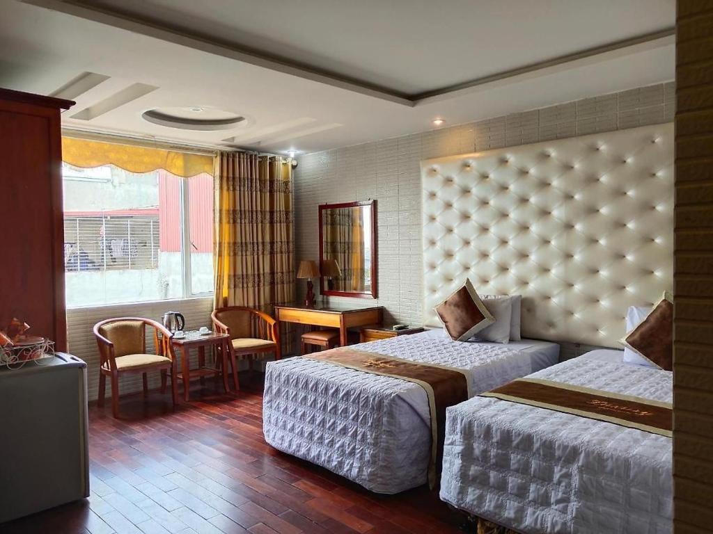 Una habitación de hotel con dos camas y un escritorio. en Luxury Hotel 1 HP- by BAY LUXURY, en Hai Phong