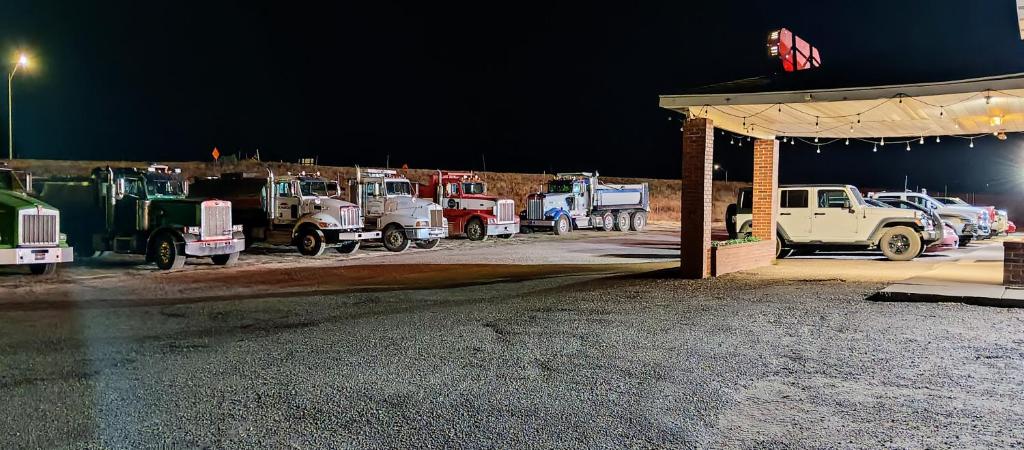 un gruppo di camion parcheggiati in una stazione di servizio di Amber Inn Motel a Bliss