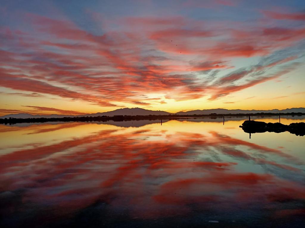 un coucher de soleil sur une étendue d'eau avec le ciel dans l'établissement Studio Mezzanine 4P avec Vue, Parking Privé - Le Barcarès - FR-1-799-16, au Barcarès