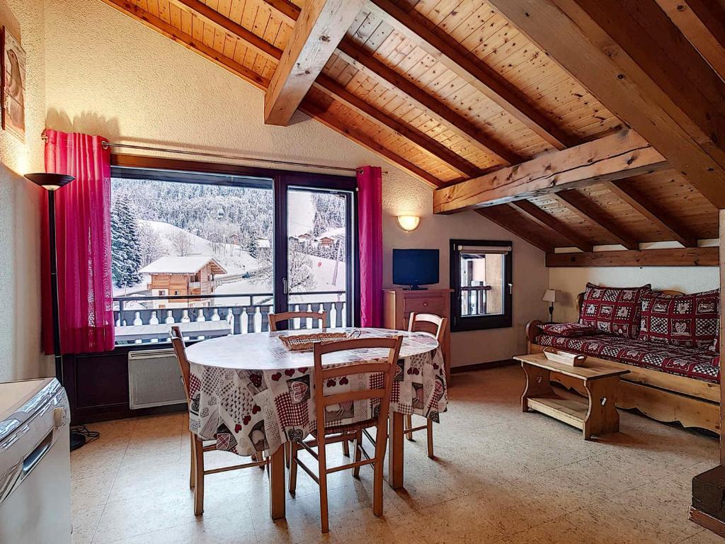un salon avec une table et un canapé dans l'établissement Appartement 8 pers à La Clusaz, Wifi, animaux admis, parking - FR-1-818-23, à La Clusaz
