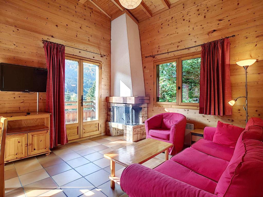 un salon avec un canapé violet et une cheminée dans l'établissement Chalet La Clusaz 6 pers, cheminée, WIFI, animaux admis, parking - FR-1-818-93, à La Clusaz