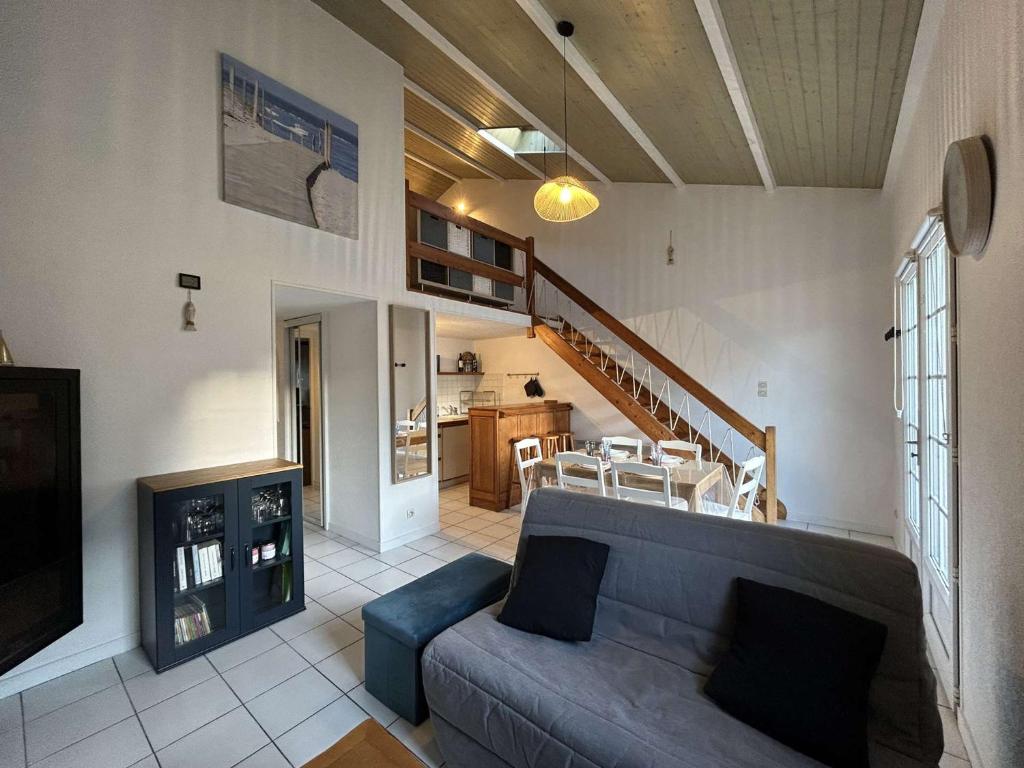 un salon avec un canapé bleu et une cuisine dans l'établissement Charmante Maison 3 Pièces, Terrasse, Près de la Plage - FR-1-224C-333, à Saint-Hilaire-de-Riez