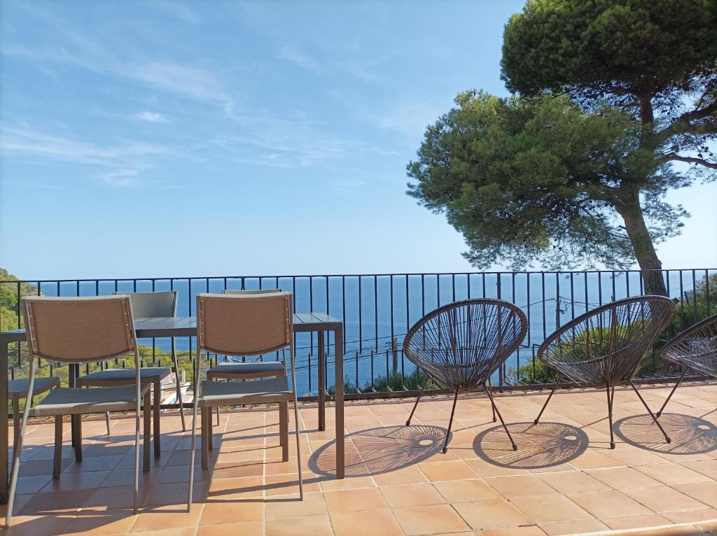 a group of chairs and a table on a patio at "Terrasse de la Mer 1" Résidence"Sol y Mar" AC-Wifi-BBQ-Piscine-Pkg in Begur