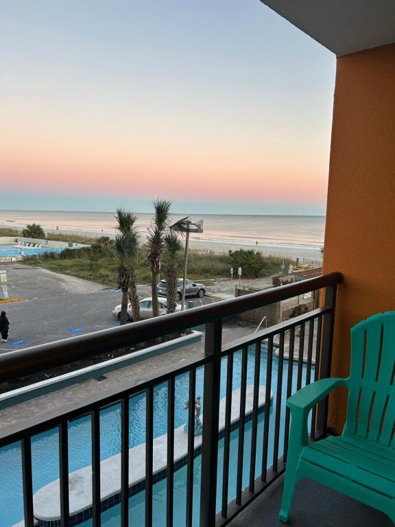 a room with a balcony with a view of the beach at Ocean View 2 Queen Studio at Landmark Resort in Myrtle Beach