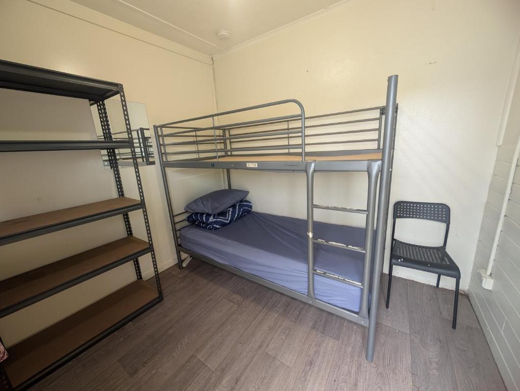 a room with two bunk beds and a chair at Wander Inn Bunbury in Bunbury
