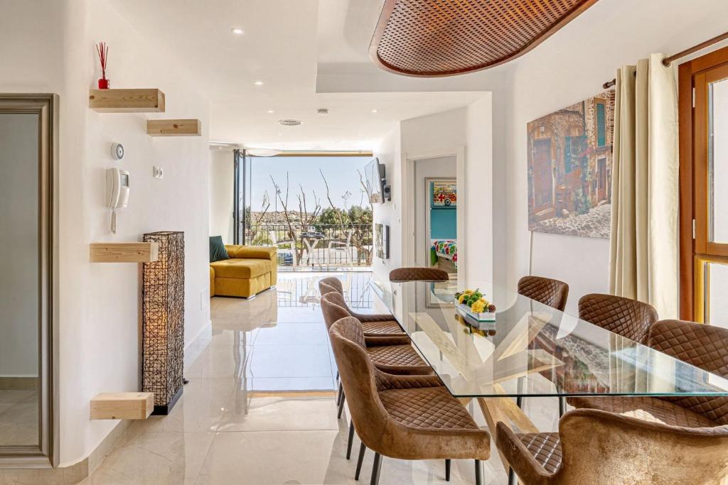 a dining room with a glass table and chairs at Spacious apartment with pool in the heart of Murcia - 128 m² in Murcia