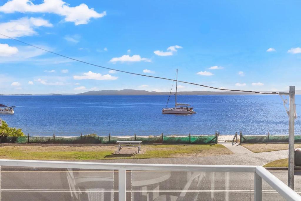 a view of the ocean with a boat in the water at Bayside 6, 21 Victoria Pde - sensational water views, linen in Nelson Bay