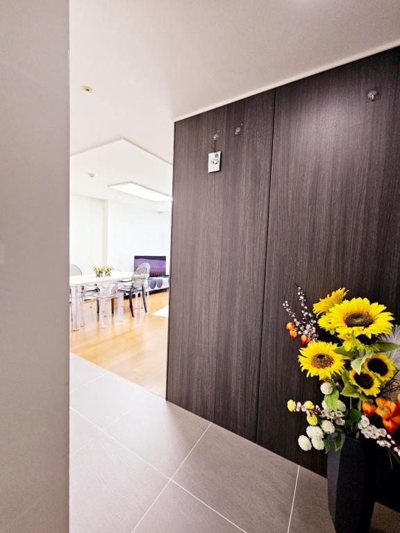 a vase of flowers on a table in a room at 2 minutes run to the sea only 152m, special benefit of Spa Waterpark 195m away in Busan