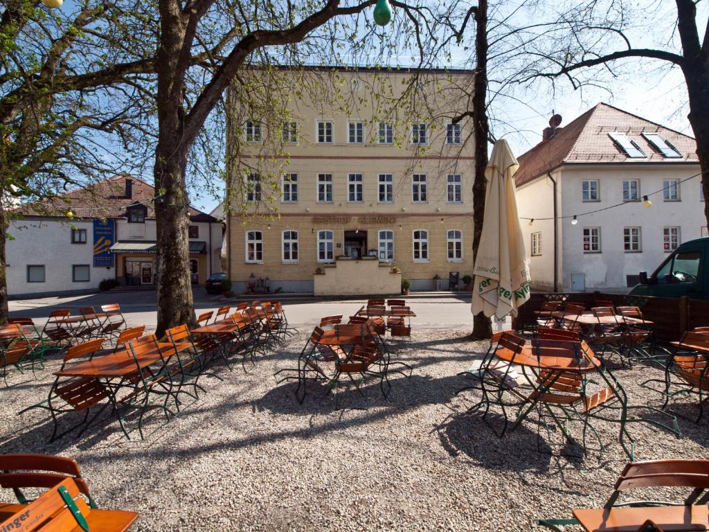 a group of chairs and umbrellas in front of a building at Gasthof Klement in Isen