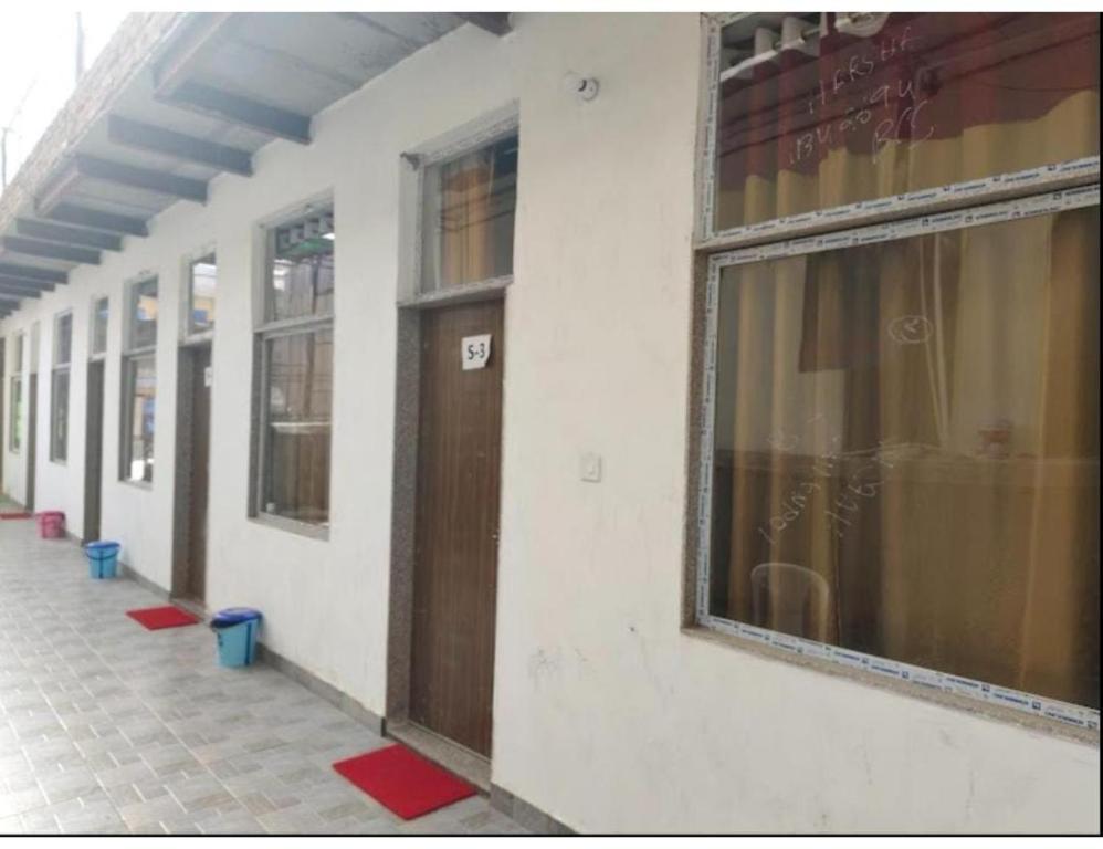 una fila de ventanas y una puerta en un edificio en Vaishnavi Shakti Peeth, Vrindavan, en Vrindāvan