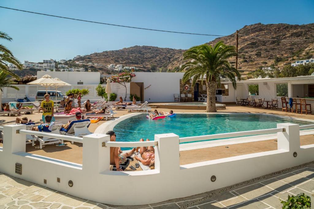 a group of people sitting around a swimming pool at Noufaro in Mylopotas
