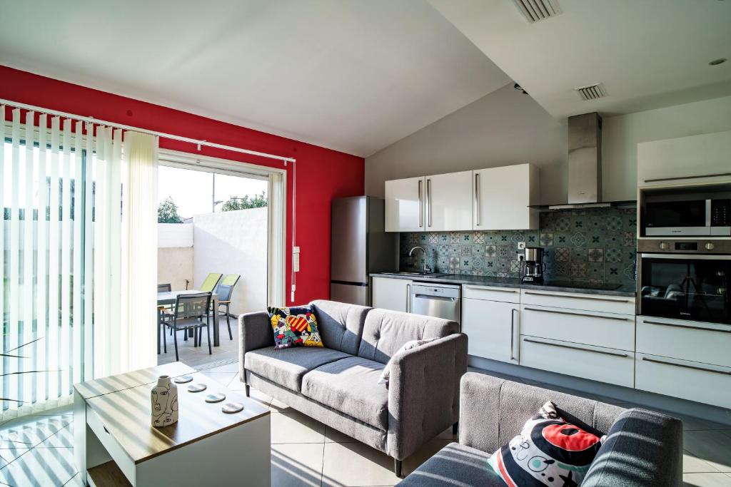 une cuisine et un salon avec un canapé et une table dans l'établissement La maison près de la mer, à Latour-Bas-Elne