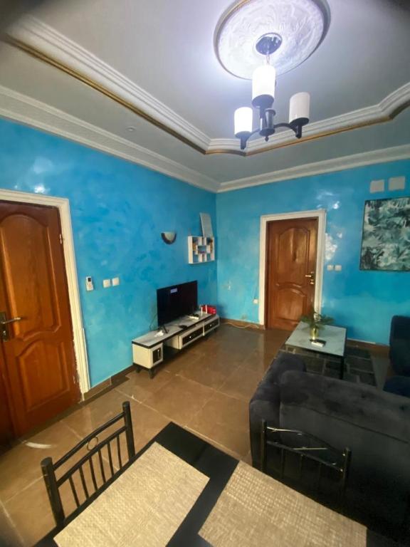 ein Wohnzimmer mit blauen Wänden und einer Couch in der Unterkunft Chez Matis in Pointe-Noire