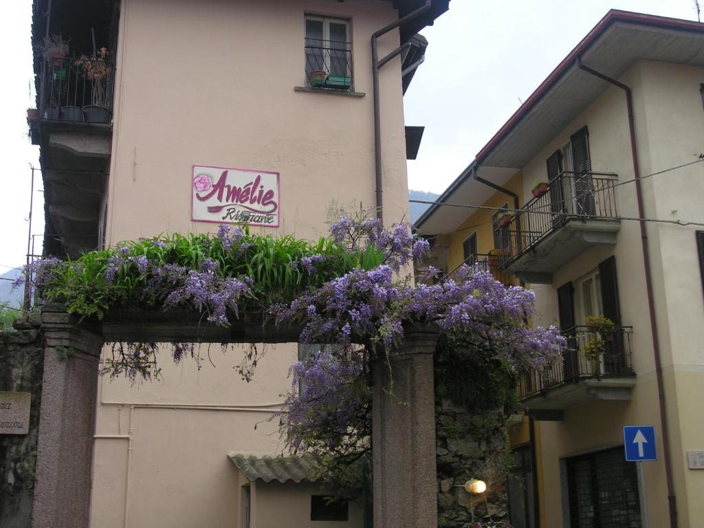 ein Gebäude mit lila Blumen darüber in der Unterkunft Affittacamere Ristorante Amélie in Baveno