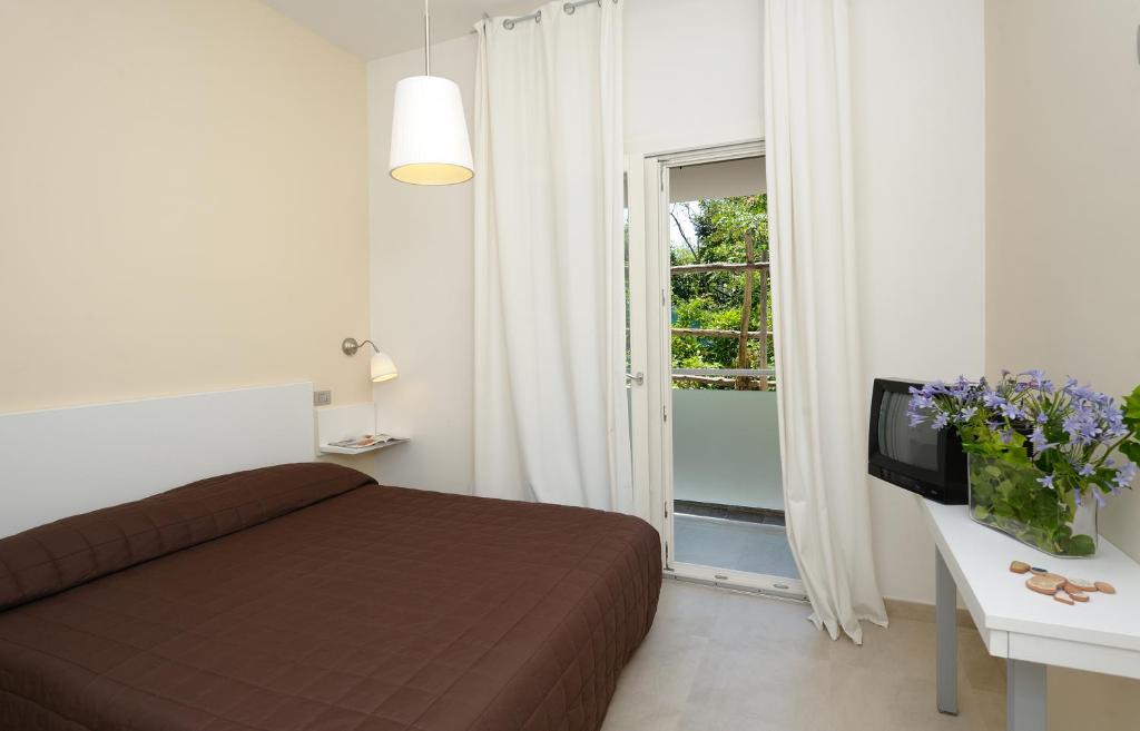 a bedroom with a bed and a television and a window at Residence La Dolce Vita in Maiori