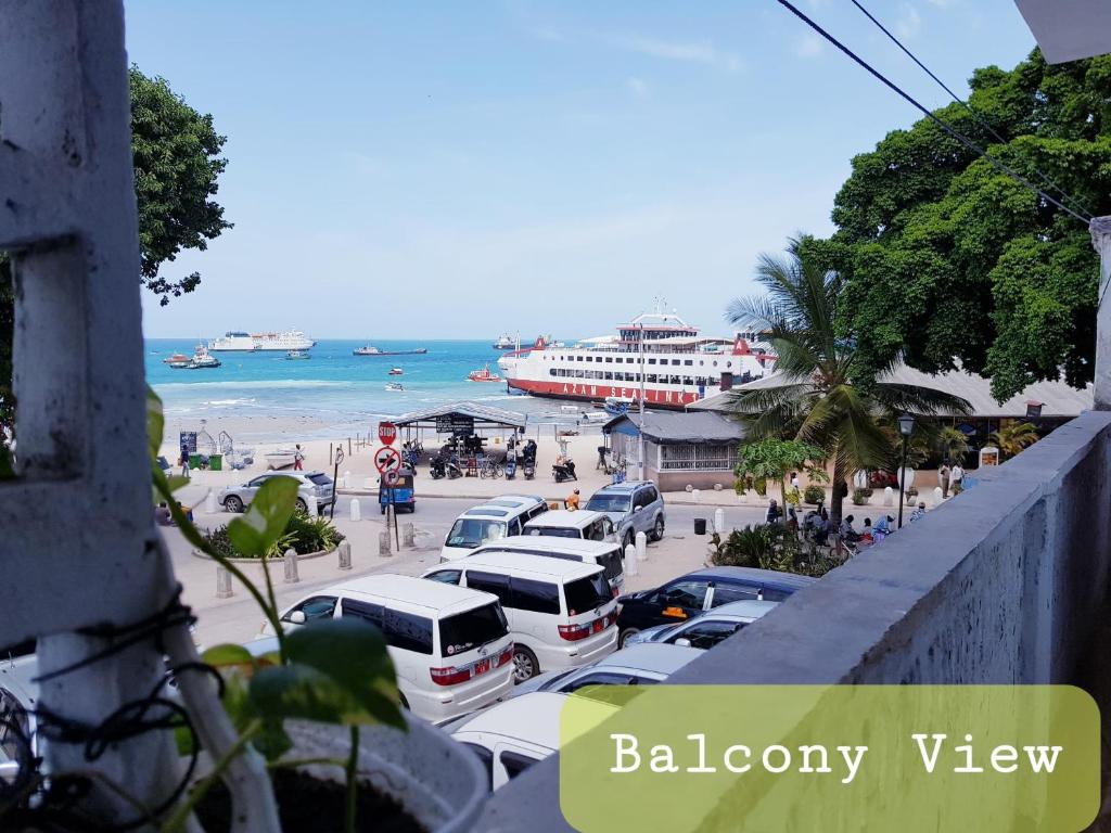 Mamdalis Private Rooms Stonetown في Ngambo: اطلاله على شاطئ فيه سيارات متوقفه في موقف سيارات