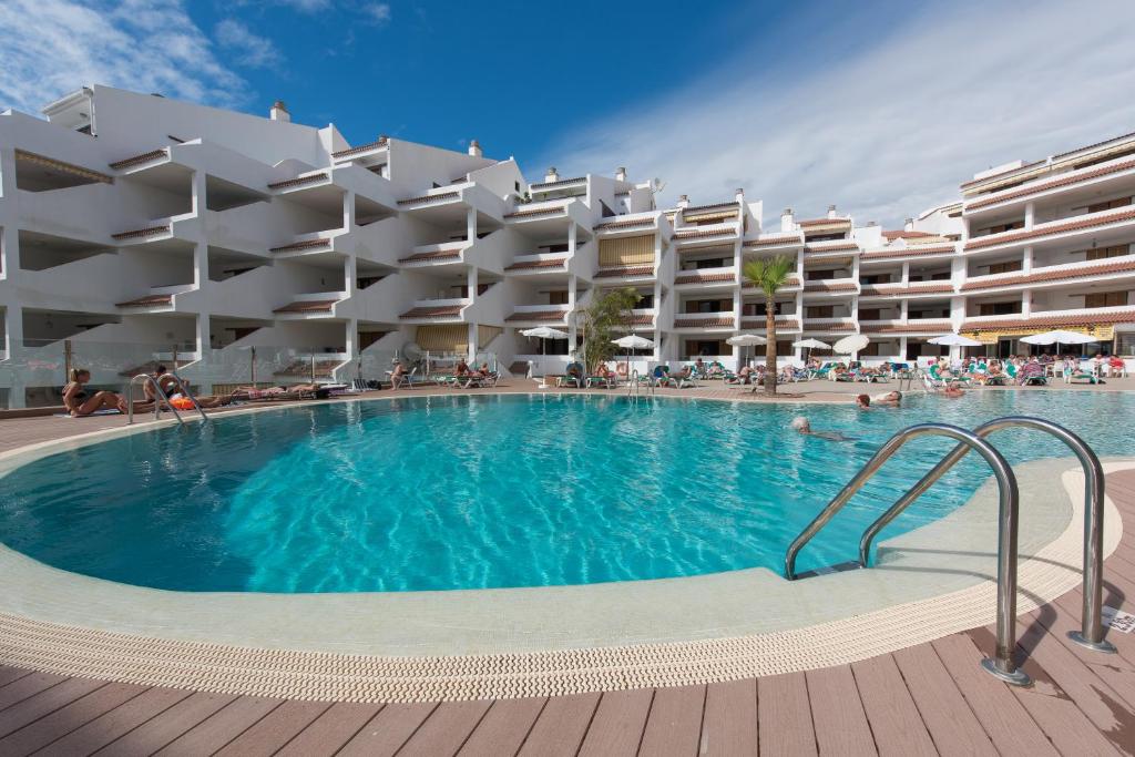 a large swimming pool in front of a hotel at Paloma Beach Apartments in Los Cristianos