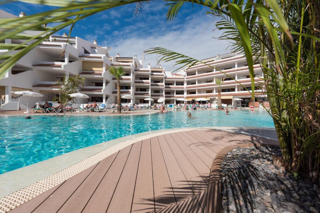 a swimming pool in front of a hotel at Paloma Beach Apartments in Los Cristianos