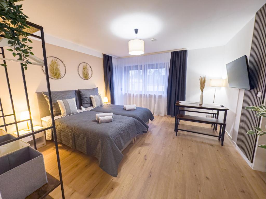 a bedroom with a bed and a table with a television at Modernes Apartment mit Balkon & Parkplatz, WiFi in Bremen
