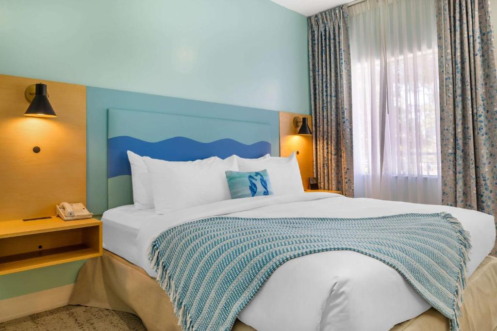 a bedroom with a large bed and a window at Quality Suites Downtown San Luis Obispo in San Luis Obispo