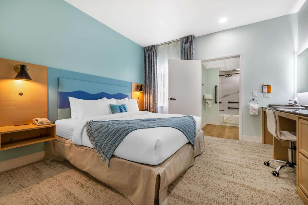 a bedroom with a bed and a desk and a bathroom at Quality Suites Downtown San Luis Obispo in San Luis Obispo