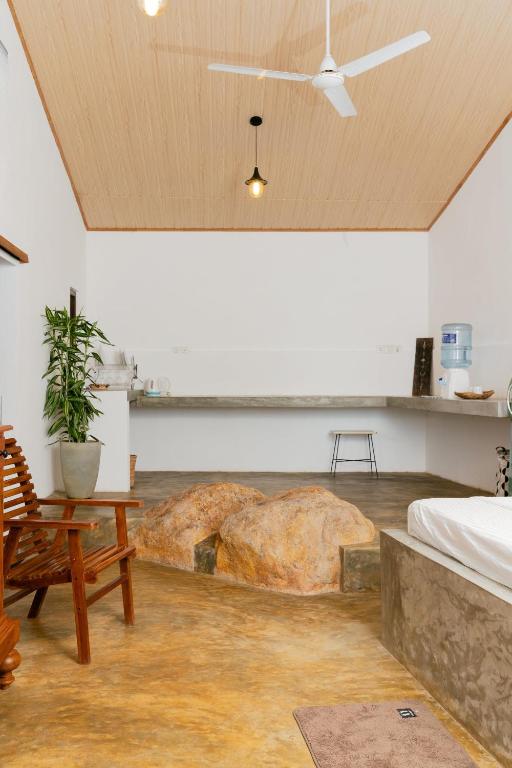 a bedroom with a bed and a large rock on the floor at THE LODGE by Eco Love in Galle