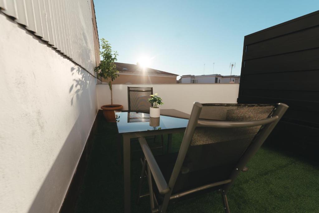een kleine tafel en een stoel op een balkon bij Macarena Suites in Cáceres