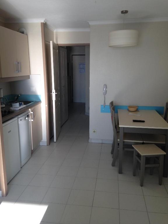 une cuisine et une salle à manger avec une table et des chaises dans l'établissement pierre et vacances, à Cannes