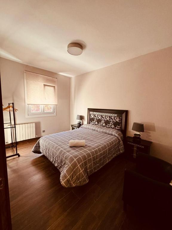 een slaapkamer met een bed met een deken en een raam bij 16 Mirasierras in Madrid