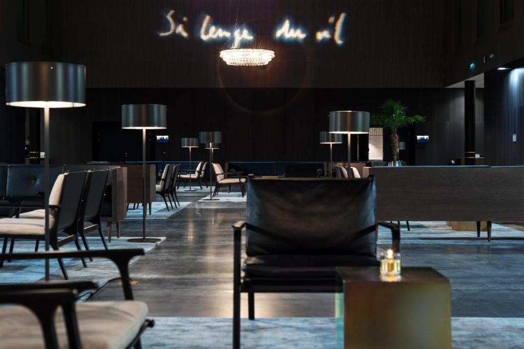 a dining room with chairs and tables and lights at Clarion Hotel Air in Sola