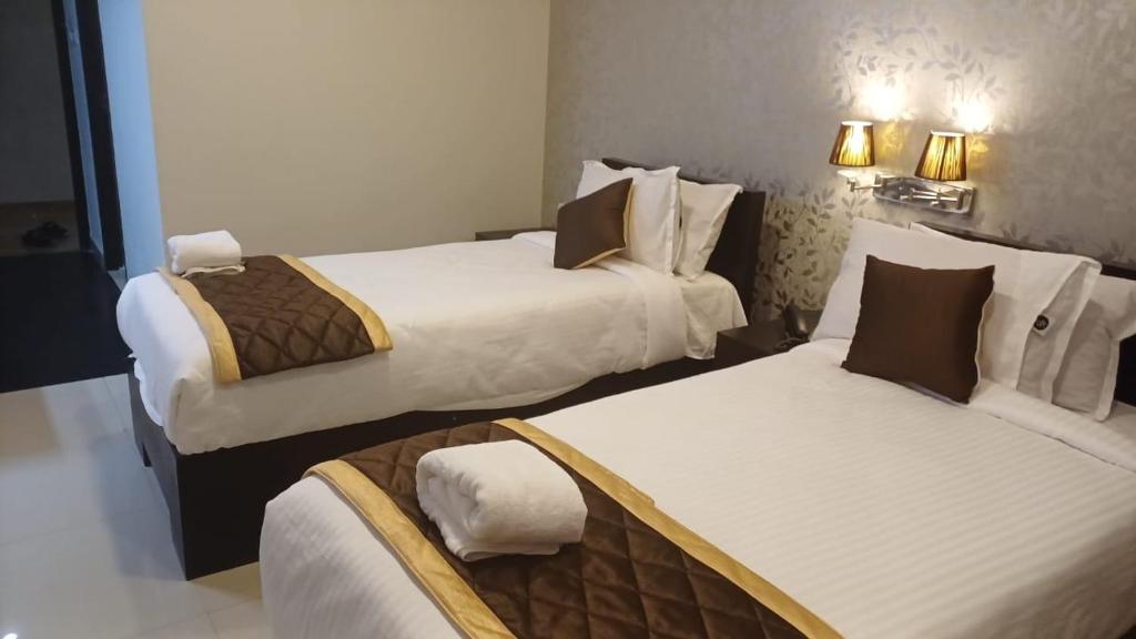 安加马尔伊Hotel Grand Regency, Angamaly的一间有两张床和两盏灯的酒店房间