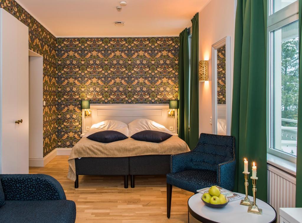1 dormitorio con 1 cama y 2 sillas en SPiS Hotell Amber en Luleå