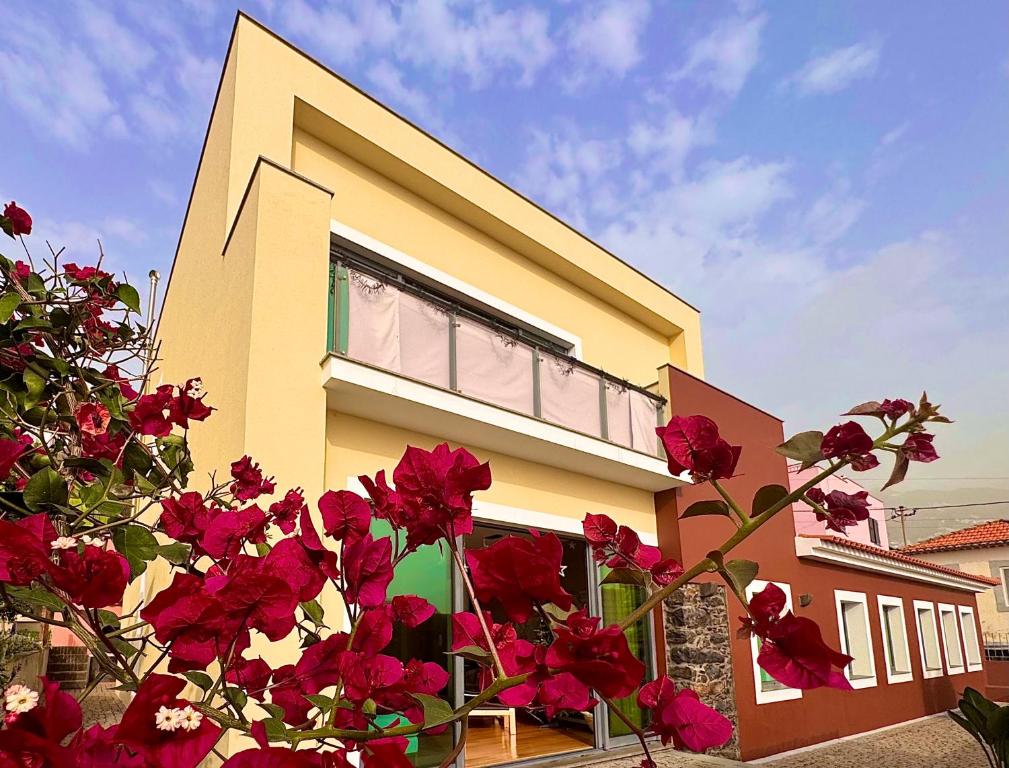 a house with red flowers in front of it at Casa dos Arrifes in Funchal