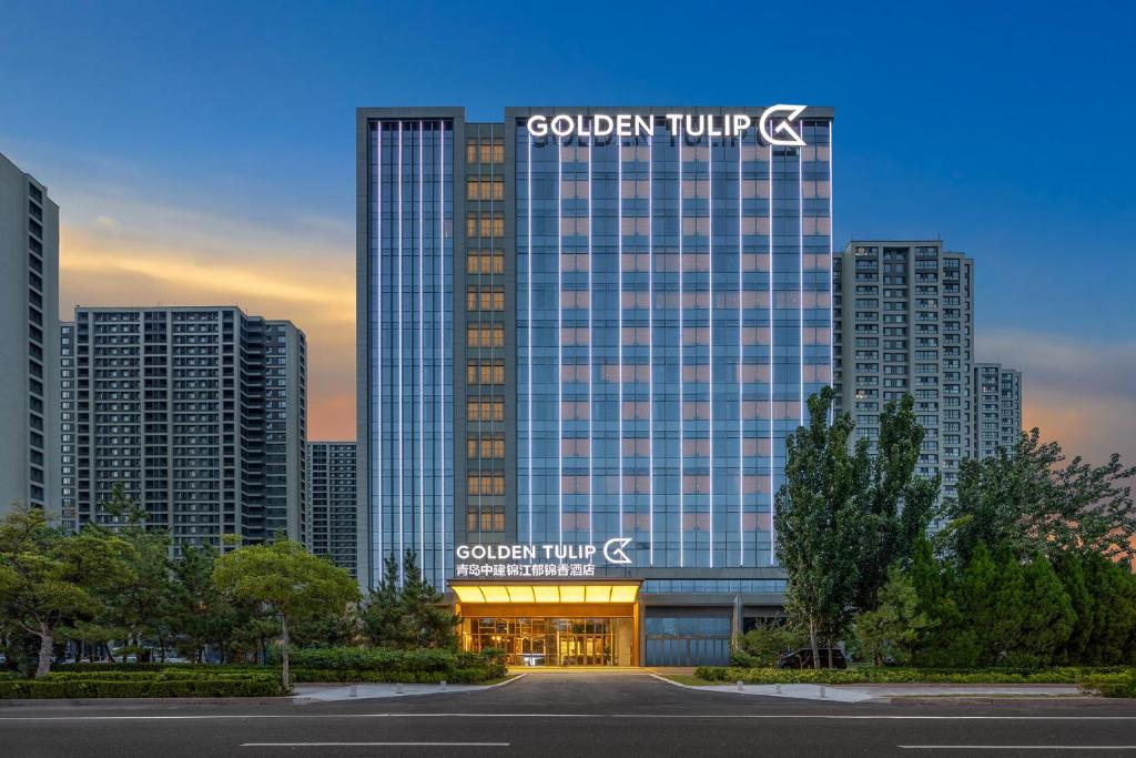 青岛Golden Tulip Qingdao Hongdao Exhibition Center Hotel的一座大建筑,上面有城市标志