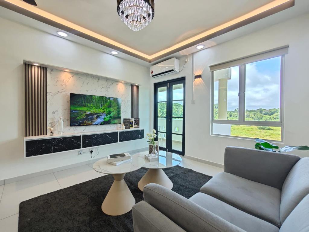 a living room with a couch and a table at Tiara Desaru by Antlerzone in Bandar Penawar